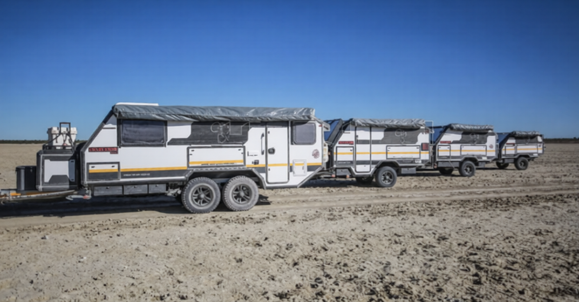 Line of off-road hybrid caravans with pop-top roofs parked on a flat outback plain